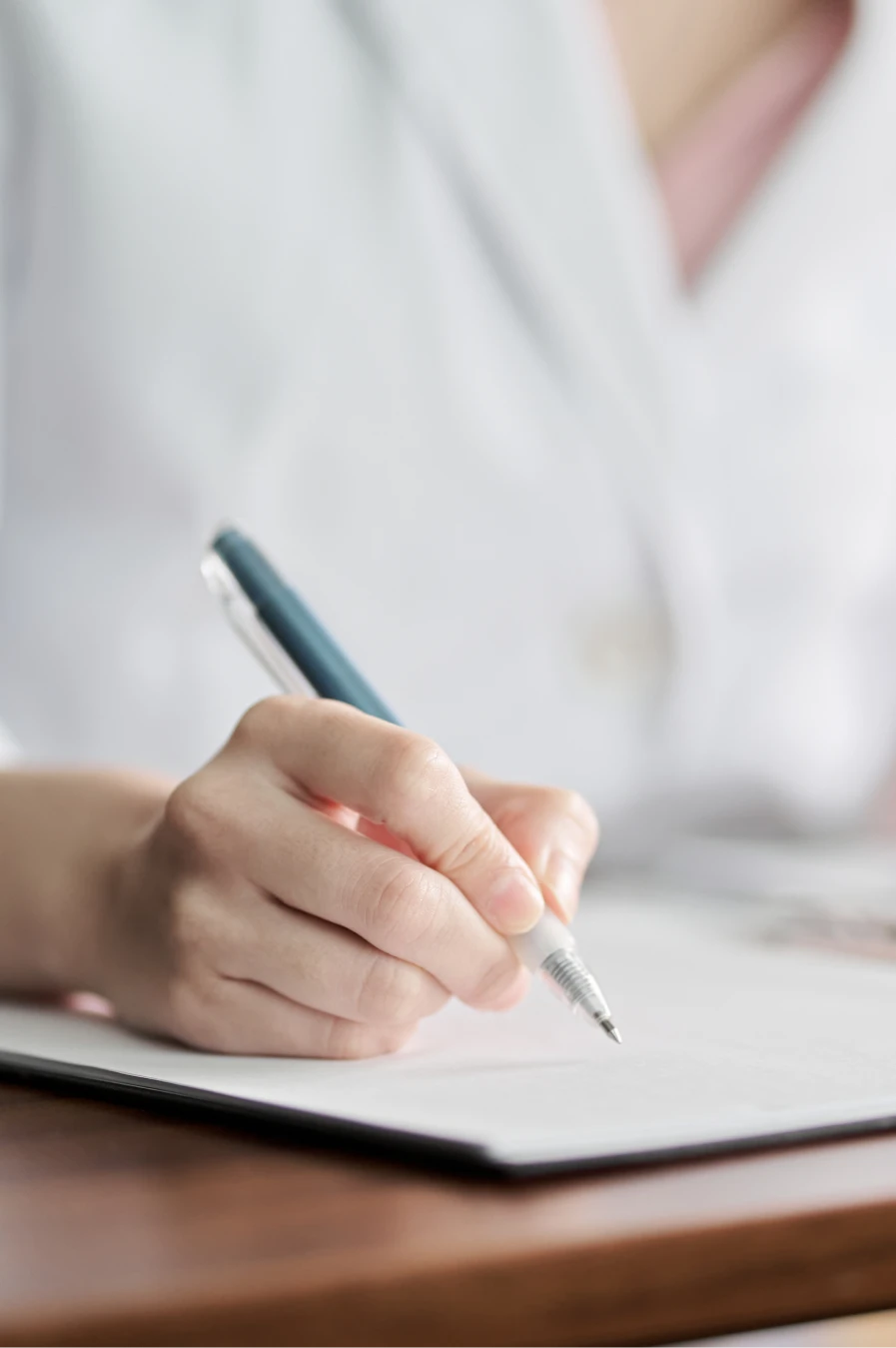 Hand mit Stift schreibt auf Papier